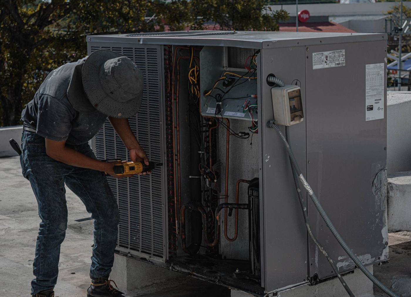 Technician working on a rooftop HVAC unit